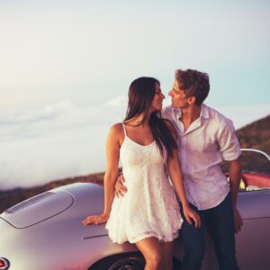 Couple Watching the Sunset with Classic Vintage Car